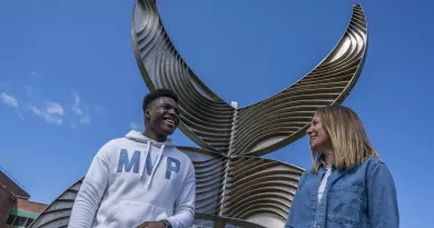 International students laughing beside Schumann building