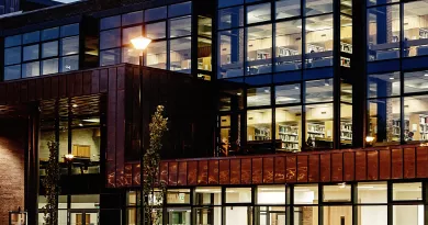 Library building lit up at evening with people