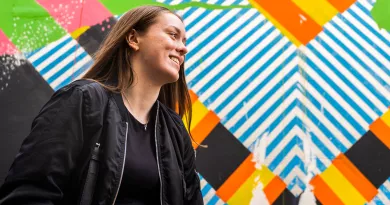 side profile of girl smiling in front of graffiti