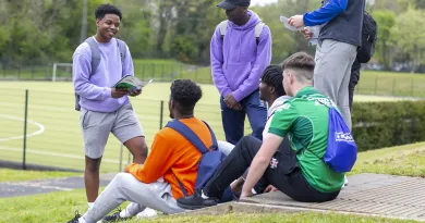 group of young men sitting on grass and chatting