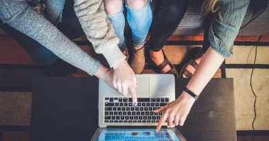 hands pointing to a laptop screen