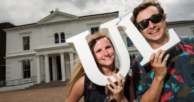 2 happy students holding UL letters