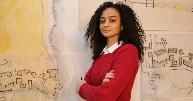 Student in red jumper in front of whiteboard