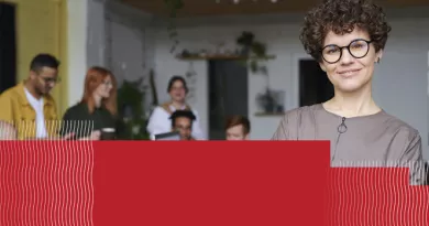 a woman in glasses pictured with her team in the background