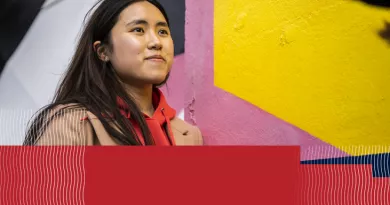 Woman on front of colourful wall mural