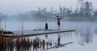 Female rower carrying boat