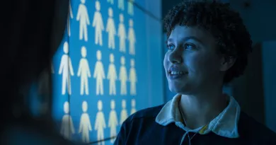 Student standing beside projector screen