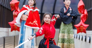 Three students in traditional Chinese clothing posing for a picture