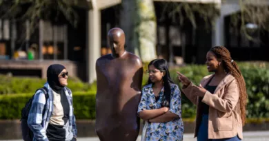 Three students standing next to Brown Thomas in the UL Plaza