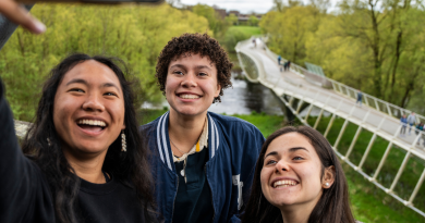 Three students taking a selfie in front of the UL Living Bridge