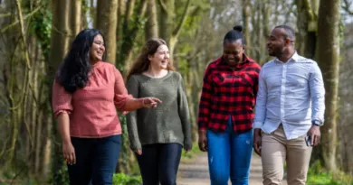 Four students walking on a footpath while talking to each other