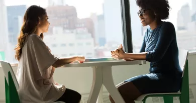 two women talking at table