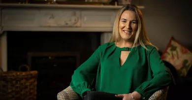 Hannah Wrixon sitting in armchair, smiling