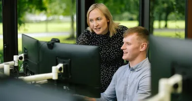 student looking at computer with supervisor assisting 