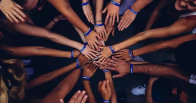 a group of hands stacked in a huddle