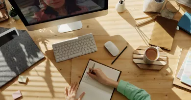 person at a desk writing in notebook