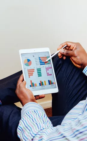 Male holding a tablet with graphs and charts