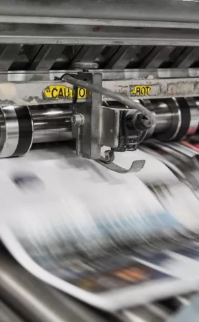 close up, high-speed shot of newspapers being printed 