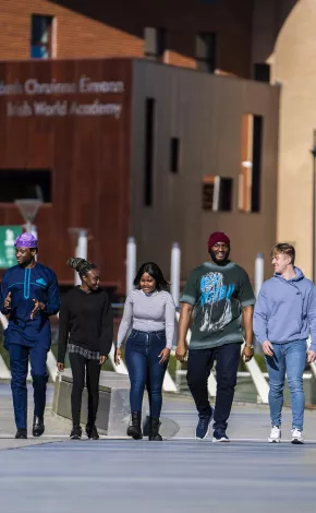 6 students walking over the living bridge chatting