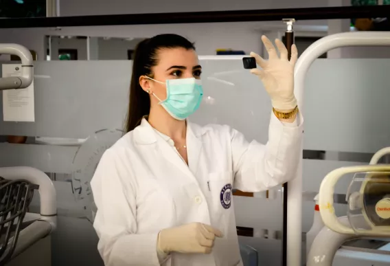 Female Doctor holding up a micro-slide.Photo by Ani Kolleshi on Unsplash