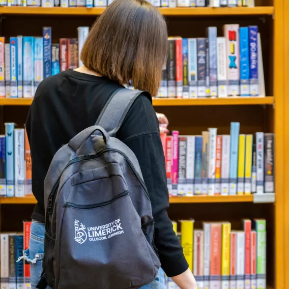 Girl looking at books in library