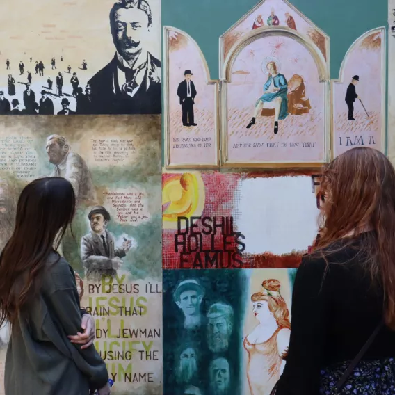 Girls reading poetry infront of wall