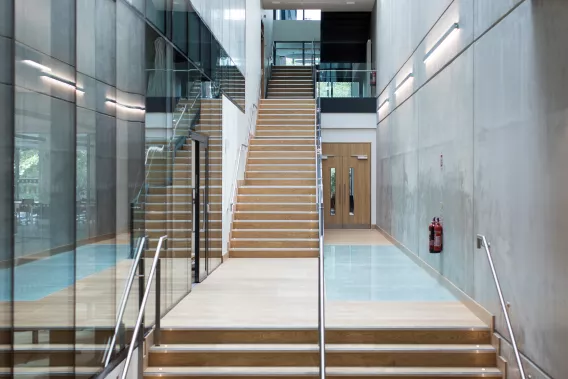 A large staircase in a building with glass windows to the left of the stairwell