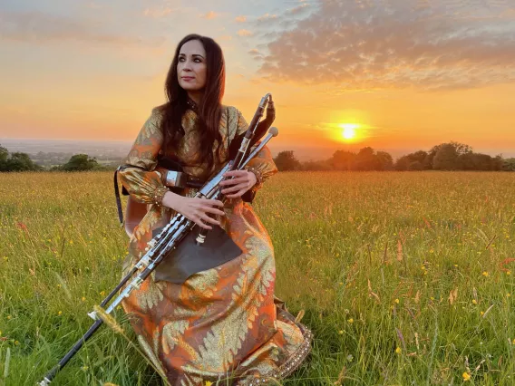 louise playing instrument in a field