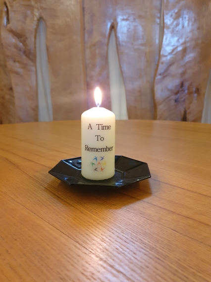 lighting candle inscribed with A Time to Remember
