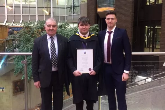 Tomás at his MA graduation in 2018 with his father and brother 