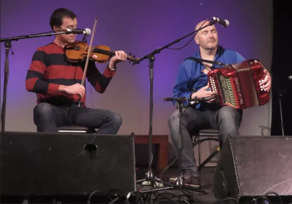 Two people on stage playing music