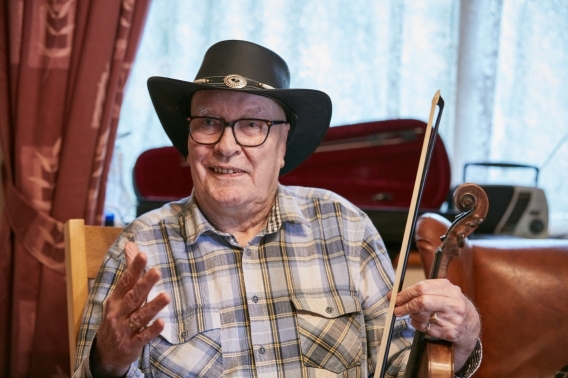 Man sitting down holding fiddle
