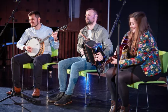 People on stage playing musical instruments