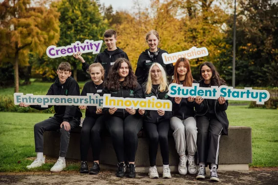 A group of people holding up signs with various words relating to entrepreneurship