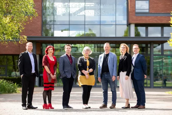 A group of people standing in front of a building on a bright day