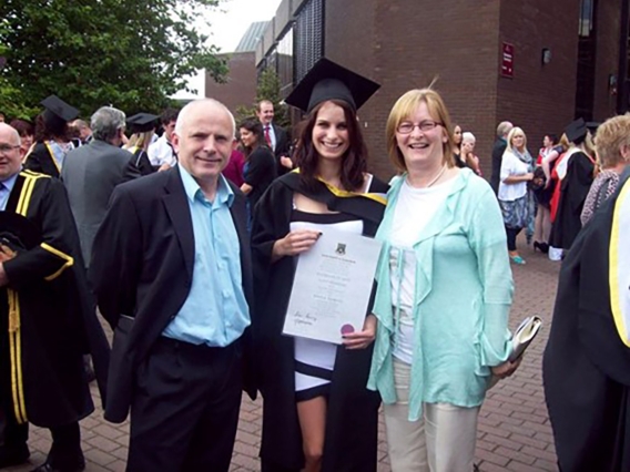 Parents with their daughter at her college graduation