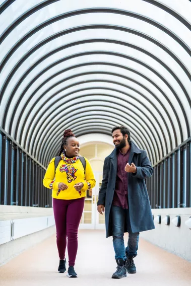 Two people walking a corridor