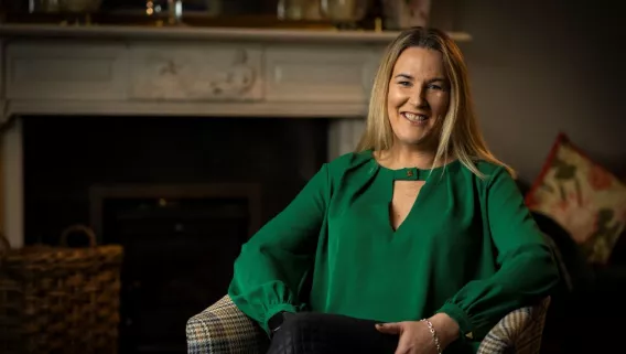 Hannah Wrixon sitting in armchair, smiling