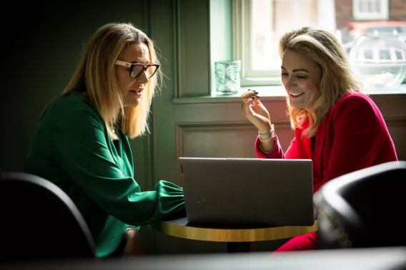 Two women looking at a single computer screen and in discussion