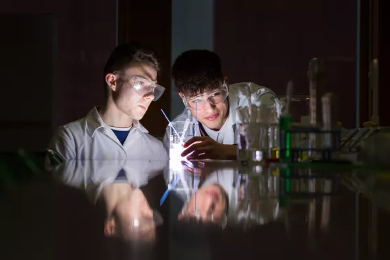 Two students looking at science equipment