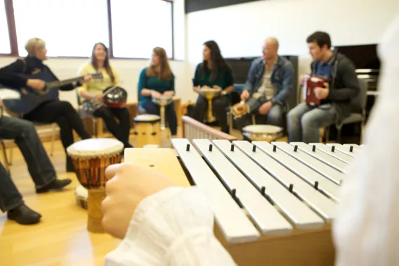 People in a circle playing musical instruments