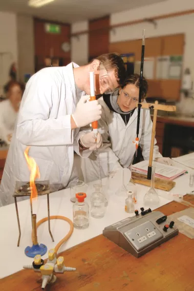 two students with a bunsen burner