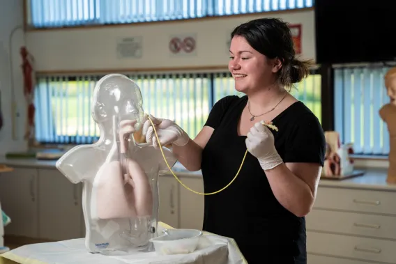 Woman with mannequin in simulation lab