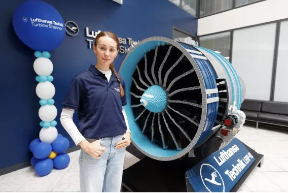 girl standing in front of lego model