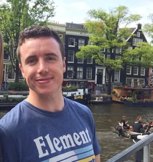 man in front of canal in Amsterdam