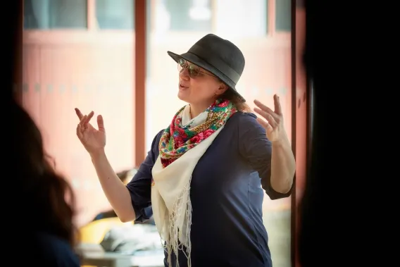 Singer with hat and scarf performing in foyer