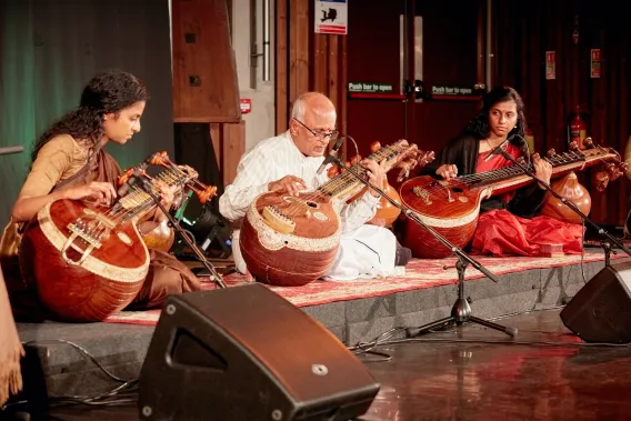 Three musicians playing traditional Indian instuments