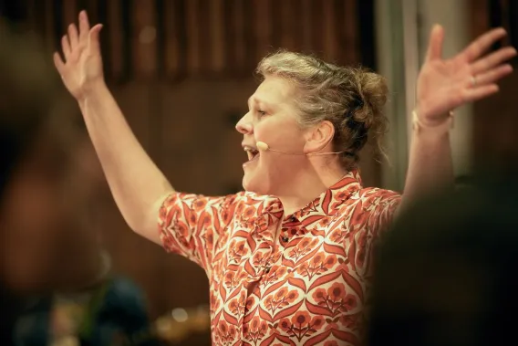 Kathleen Turner conducting choir members