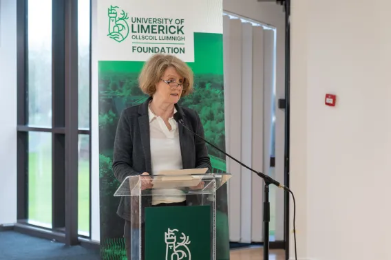 A picture of Professor Ann Ledwith speaking at the event. She is standing in front of a podium