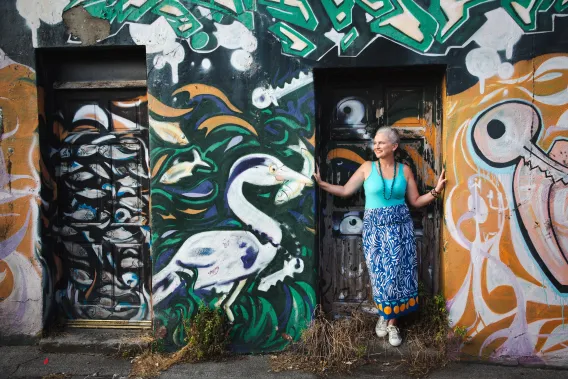 Dr Roisin Ni Ghalloglaigh standing in a colourful doorway